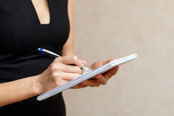 Slender girl holding a Notepad and pen