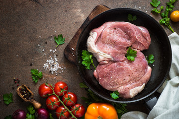 Raw pork meat in the pan. Top view