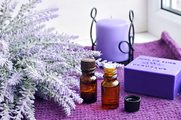 Fototapeta na wymiar Bottles of essential oil, soap and candle with lavender