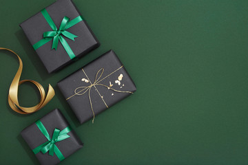 Christmas gifts on dark green background with copy space, flat lay
