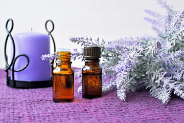 Bottles of essential lavender oil with candle