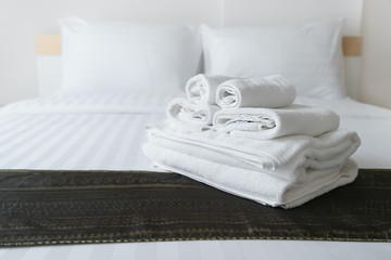 Freshly laundered fluffy towels on bed in hotel