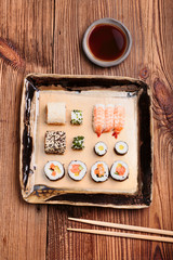 Sushi set on pottery plate with chopsticks and soy sauce in bowl