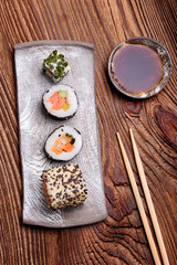 Sushi set on pottery plate with chopsticks and soy sauce in bowl