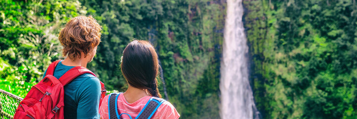 Hawaii travel tourists at nature waterfall panoramic landscape banner. Travelers couple looking at Akaka Falls in Big Island, Hawaiian famous attraction, USA.