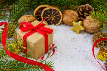 Christmas gift with red ribbon on snow background.