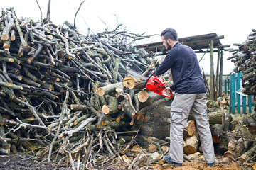 A man is sawing wood with an electric saw.