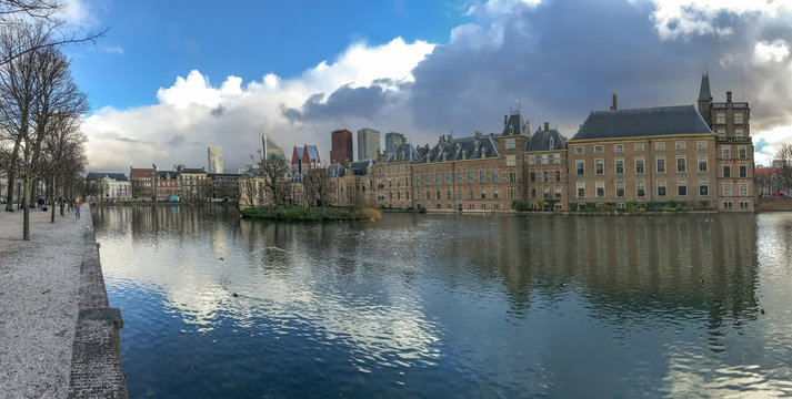 Panorama of the Dutch parliament building reflection on the pond under a freezing bright midday