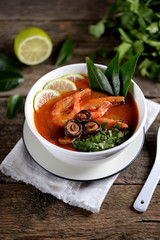 Thai soup Tom Yam with mushrooms, shrimps, lime and cilantro.