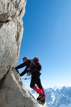 Climbing in Chamonix. Climber on the stone wall of Aiguille du Midi