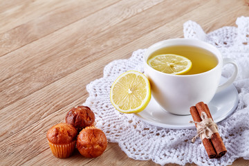 white cup of tea with cookies on a wooden background