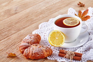 white cup of tea with cookies on a wooden background