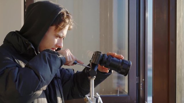 young man shoots on a compact camera on a tripod