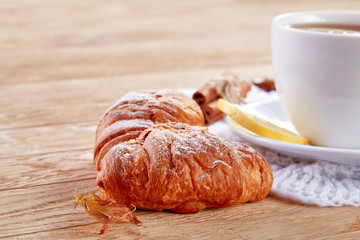 white cup of tea with cookies on a wooden background