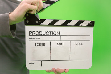 Video producer man holding movie clapper board on green background