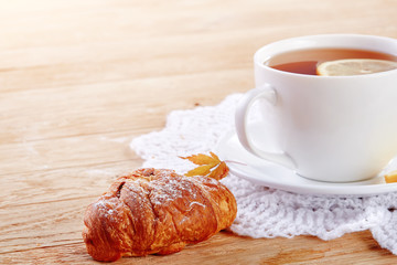 white cup of tea with cookies on a wooden background