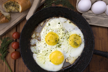 appetizing fried eggs in an old frying pan