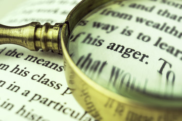 The word 'anger' emphasized by a magnifying glass.