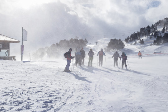 Group of mountain skiers during strong wind and a bizzard