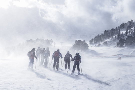 Group of mountain skiers during strong wind and a bizzard