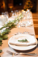 Christmas dinner feast. A decorated dining table with champagne glasses and christmas tree in background