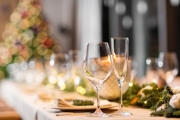 Christmas dinner feast. A decorated dining table with champagne glasses and christmas tree in background