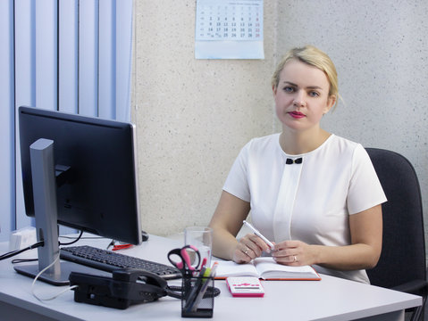 Young beautiful blonde girl is working in the office close-up.