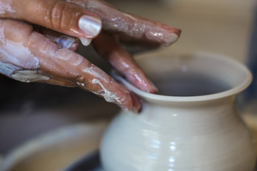 Fototapeta na wymiar Potter molding a shape to pot with fingers, close up potter hands, toned