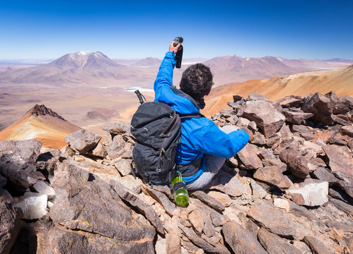 Tourist backpacker making selfie mountain peak, rear view, Bolivia.