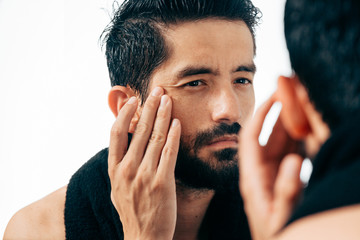 Man in front of mirrror looking at his wrinkles