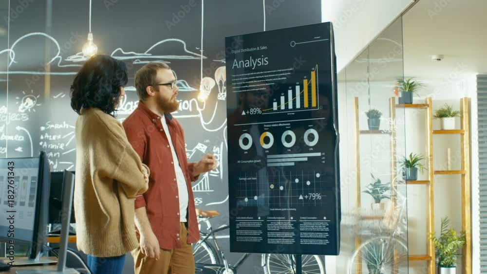 Aufkleber Female Developer and Male Statistician Use Interactive Whiteboard Presentation Screen to Look at Charts, Graphs and Growth Statistics.  Shot on RED EPIC-W 8K Helium Cinema Camera.