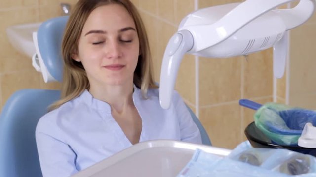 Patient in the dentist's office spits into the basket