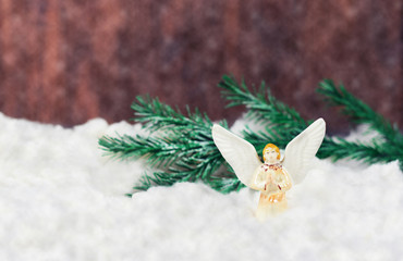 Fototapeta na wymiar toy angel with wings on white snow