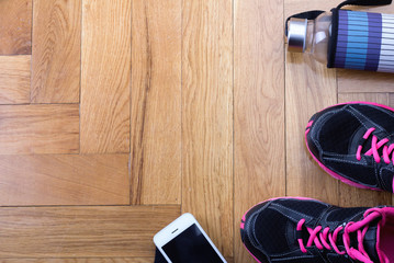 Sport shoes with bottle and phone on floor