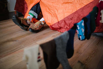 Feet in happy socks. Man is relaxing near tent and warming up his feet in happy socks. - 182763188