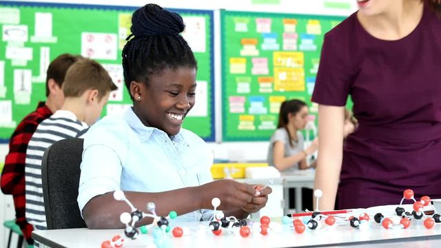Teacher And Pupil Using Molecular Model Kit In Science Lesson
