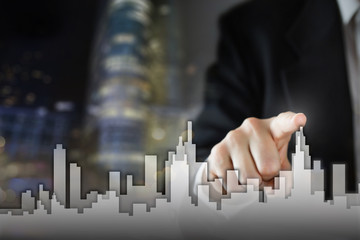 Businessman Activate Growth Process, choosing house, real estate city concept. Skyline Hand pressing the house icon on virtual screen. Business, technology, internet and networking concept. Copy space