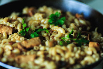 close-up of pasta with meat and greens in a frying pan