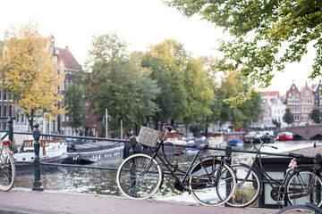 Fototapeta premium Bicycles and flowers in Amsterdam Holland Netherlands near famous UNESCO world heritage canals Singel with typical dutch houseboats