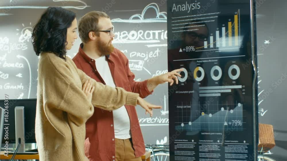 Aufkleber Female Developer and Male Manager Use Interactive Whiteboard Presentation Touchcreen to Look at Charts, Graphs and Growth Statistics. Shot on RED EPIC-W 8K Helium Cinema Camera.
