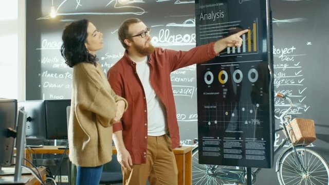 Female Project Manager Holds Meeting Shows Statistical Graphs and Charts on the Interactive Whiteboard Touchscreen Device. Shot on RED EPIC-W 8K Helium Cinema Camera.