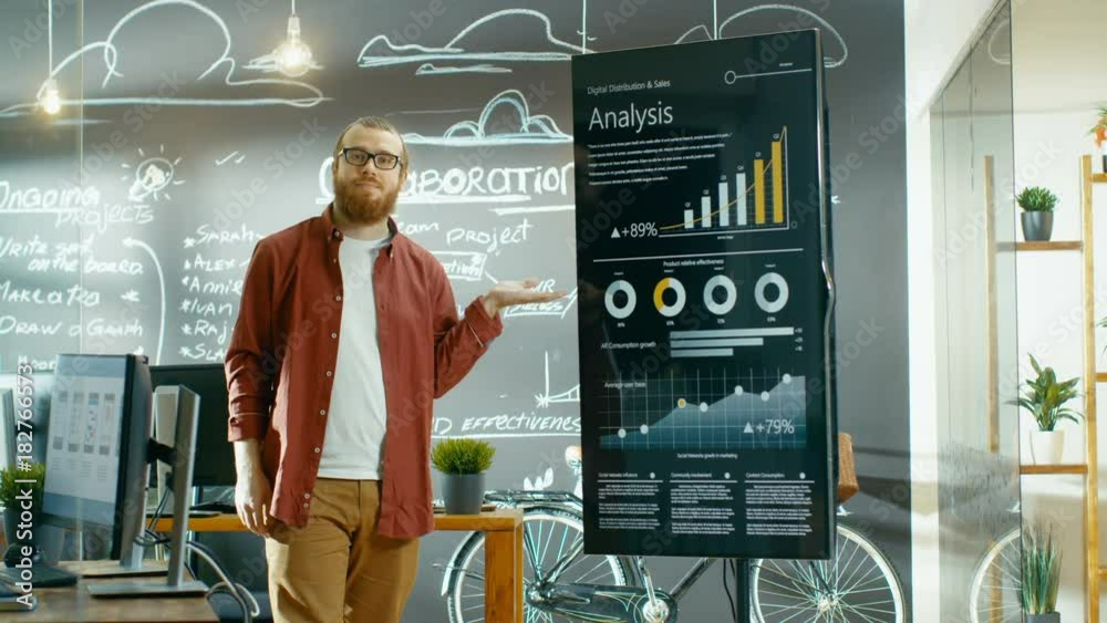 Poster Male Developer Looks at Interactive Whiteboard with Mock-up Green Screen. He Points at Display with Presenting Gesture and a Smile. Shot on RED EPIC-W 8K Helium Cinema Camera.