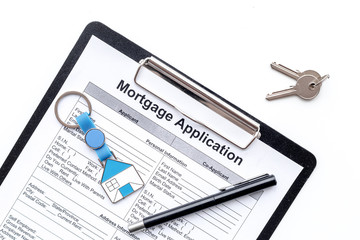 Mortgage application near apartment keys on white background top view