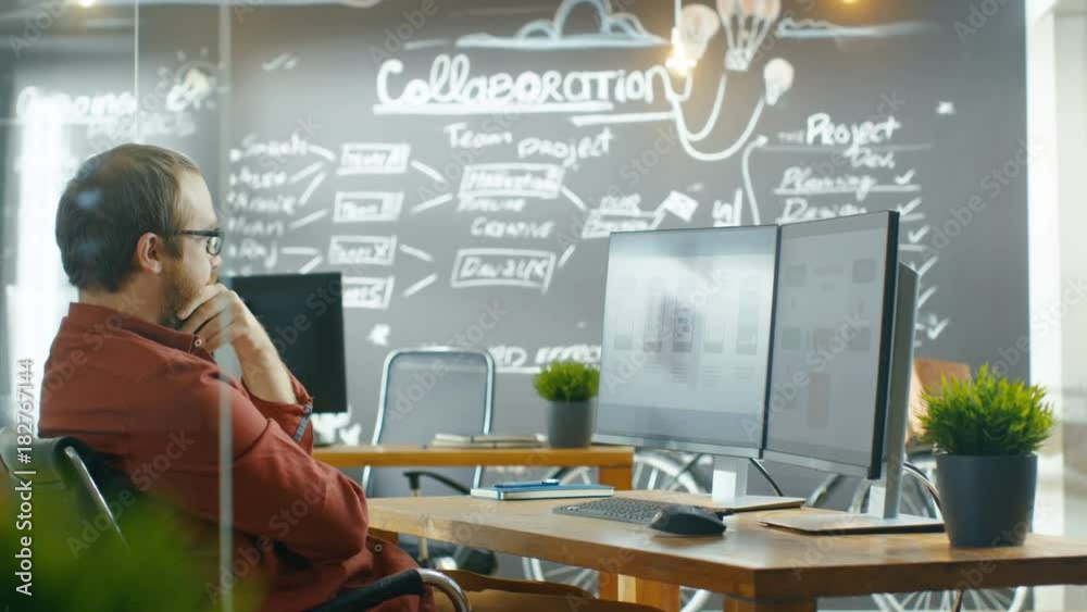 Poster Male Mobile Video Game Application Developer Works on a Personal Computer, Designing Wireframe. He Works in the Creative Indie Studio. Shot on RED EPIC-W 8K Helium Cinema Camera.