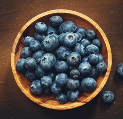 Overhead view of fresh Blueberries on dark wooden background with copy space