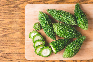 Bitter melon or bitter gourd on wooden tray. Free space for taxt