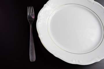 Top view empty white plate on black background