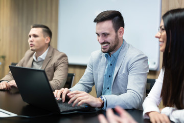 Businesspeople working on computer in conference room