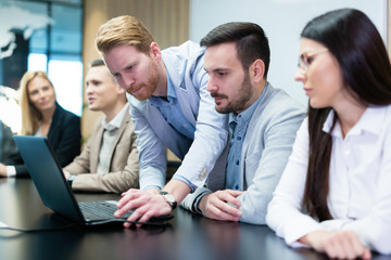 Businesspeople working on computer in conference room