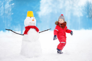 Fototapeta na wymiar Kid during stroll in a snowy winter park